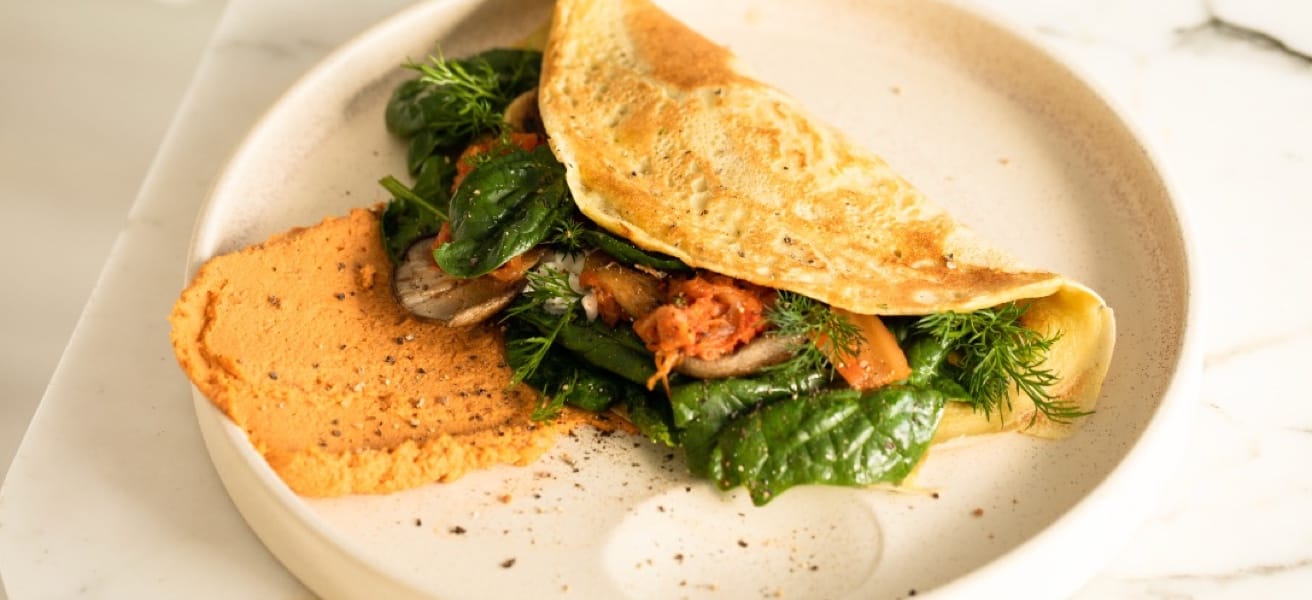 A freshly cooked omelette served with greens